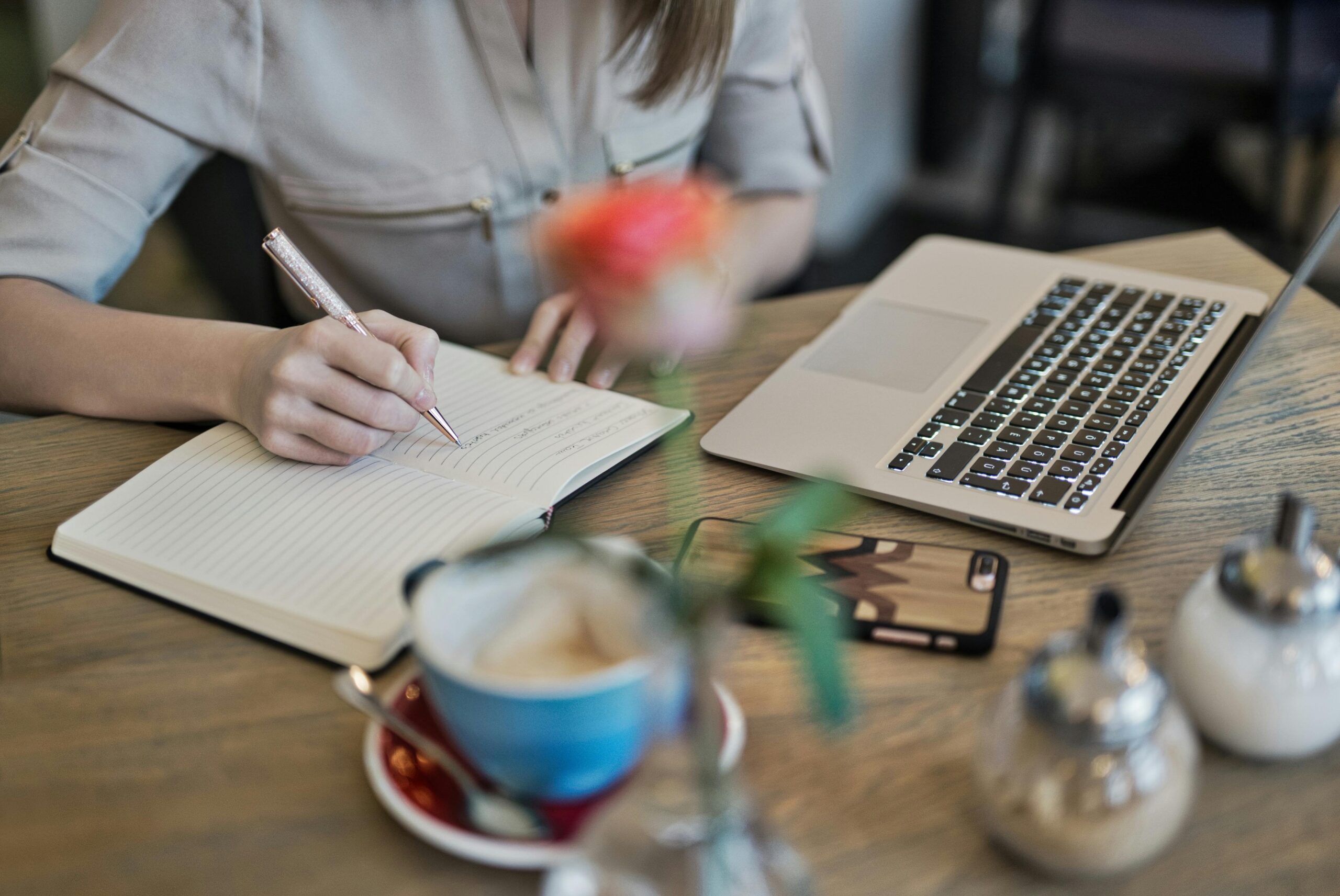 Person with laptop and notepad working on their website copy.