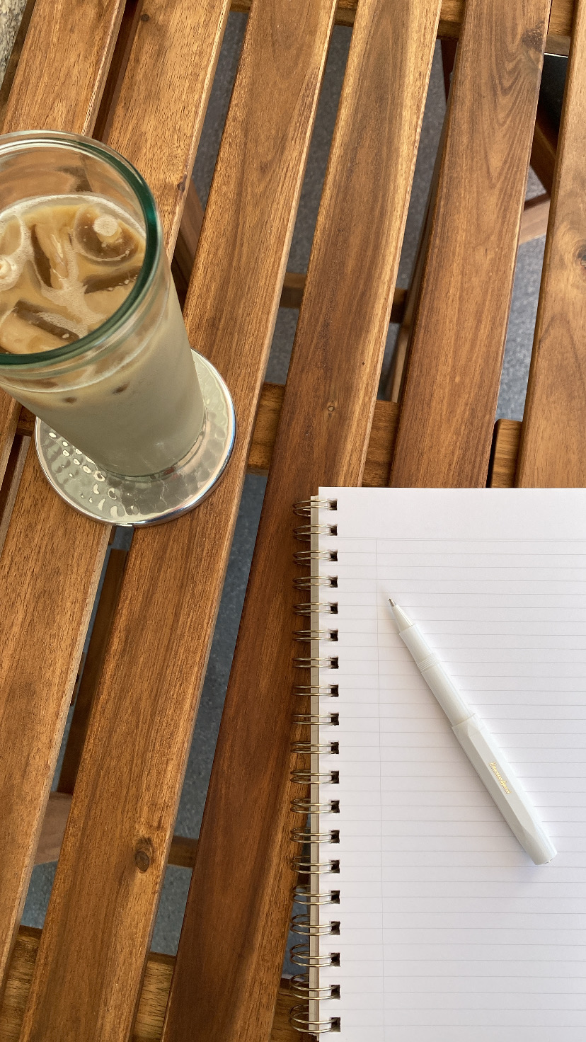 A coffee and notepad on a table, representing tips for writing website copy that connects
